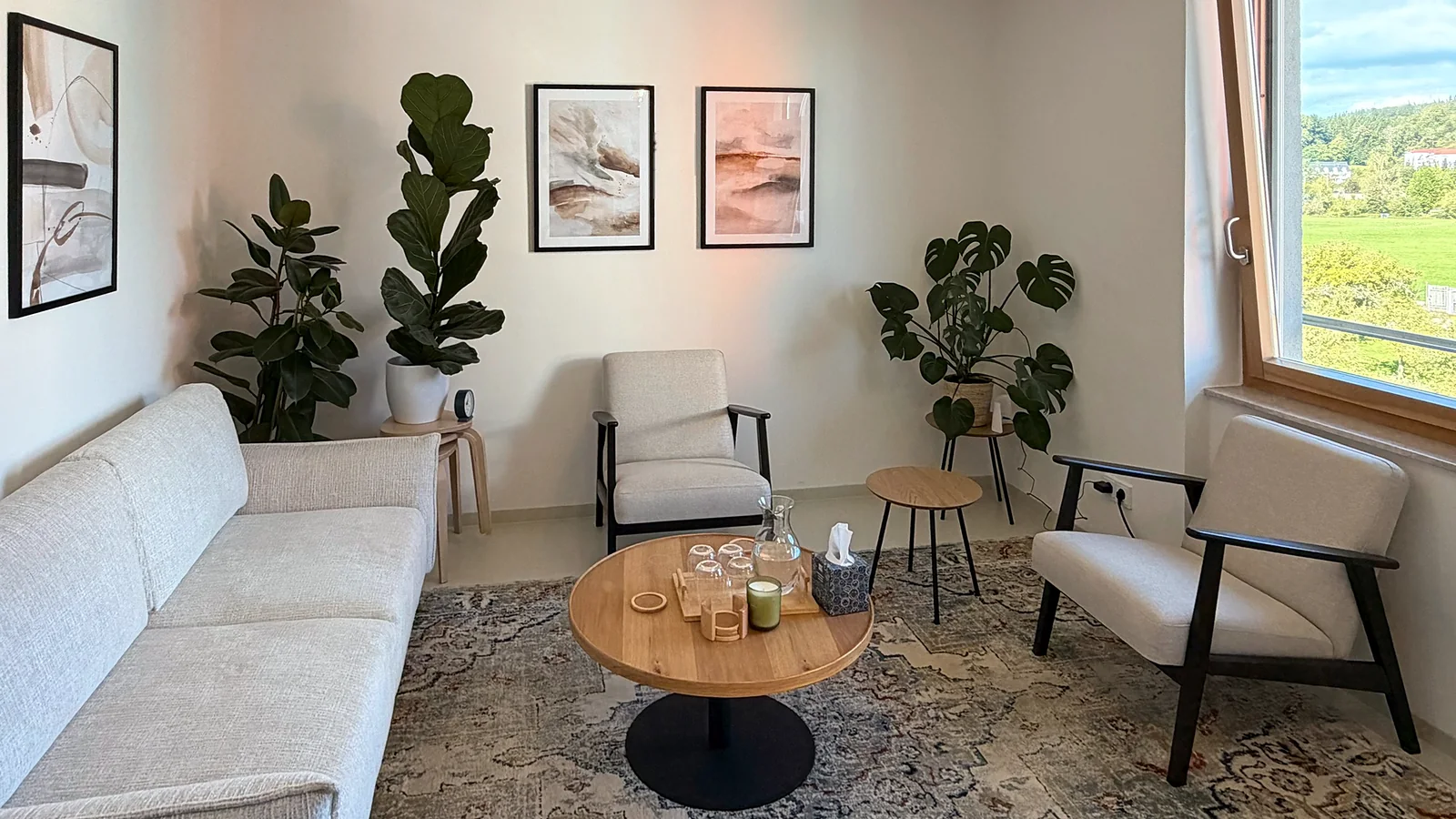 Praxisraum mit Sofa, Sesseln und Pflanzen